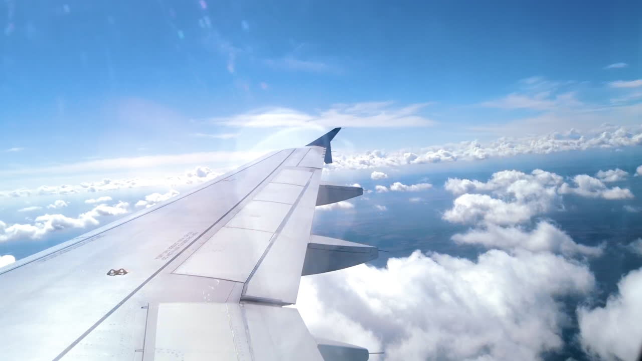 View from an airplane window of the aircraft wing in the clouds