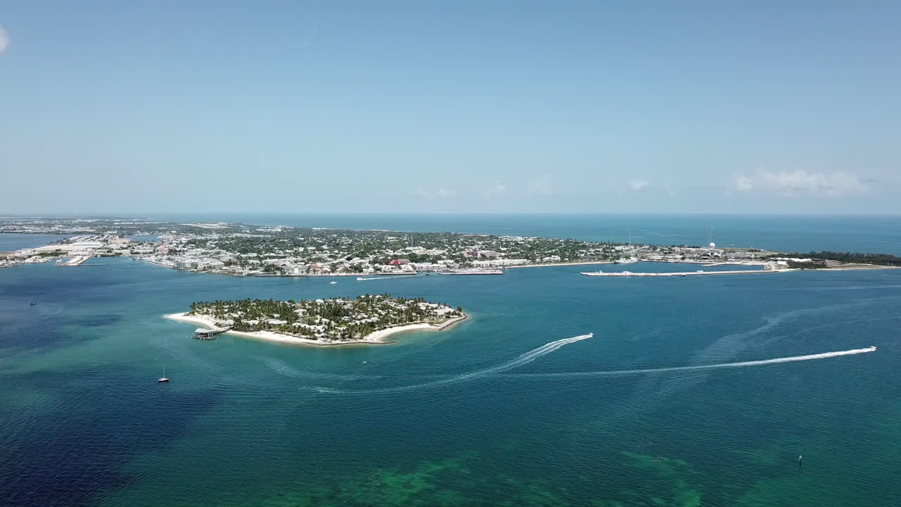 Panoramic drone shot overlooking bright and sunny Key West Florida island in turquoise water