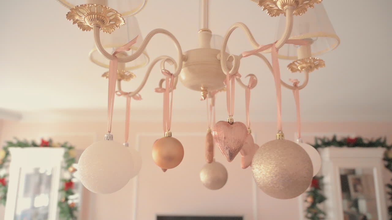 Pink and white decorations hanging on a chandelier in a pink room