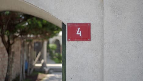 a red sign with the number four on it, attached to a wall.