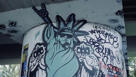 modern drawing statue of liberty on column at skate park. graffiti on wall.