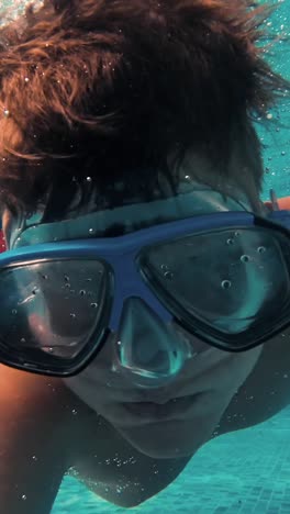 un niño bajo el agua se divierte en la piscina.