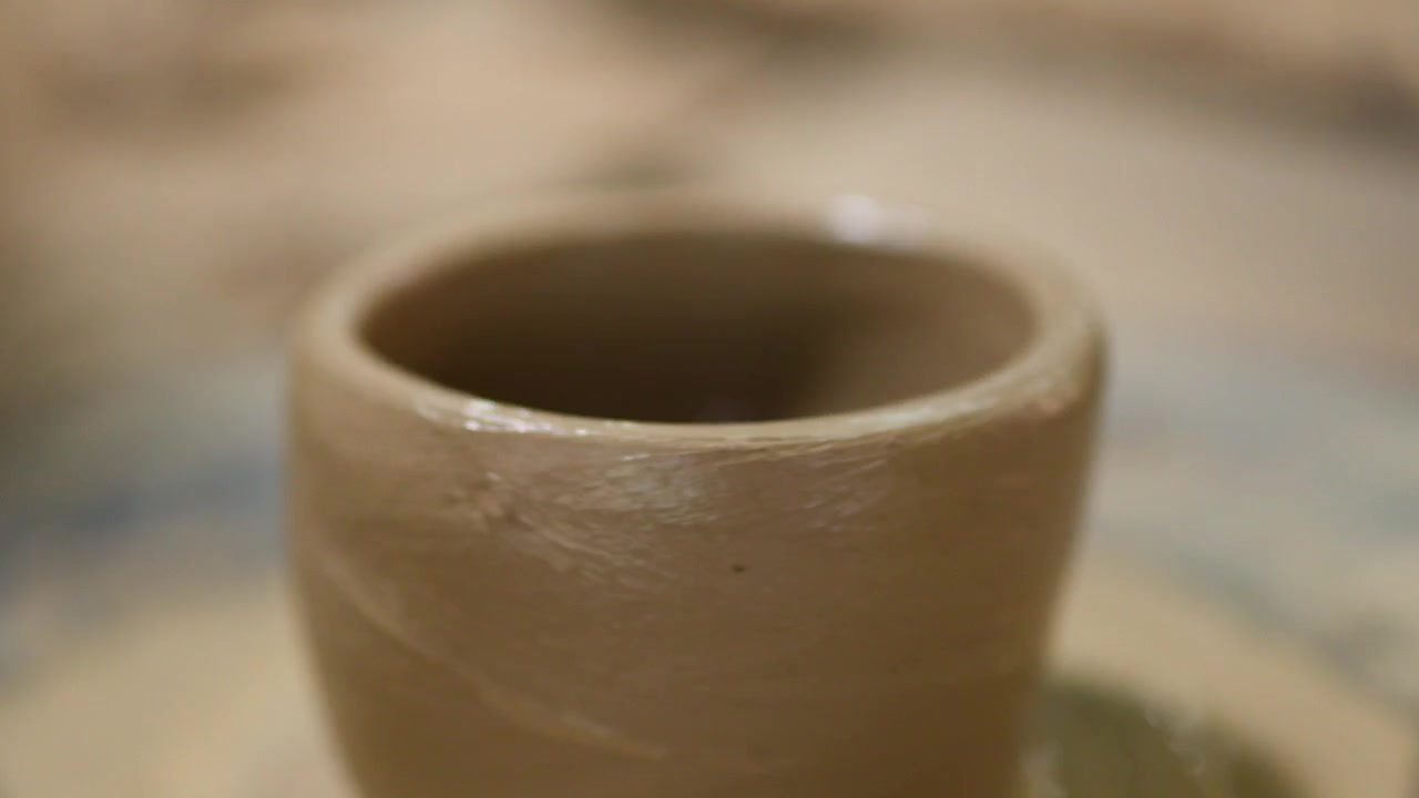 Un vaso di argilla bagnata gira su un tornio da vasaio rotante in un laboratorio in Thailandia