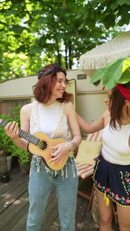 two friends playing ukulele outdoors