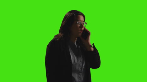 Geschäftsfrau,-Die-Auf-Dem-Mobiltelefon-Vor-Einem-Greenscreen-Studiohintergrund-Mit-Schwacher-Beleuchtung-Telefoniert