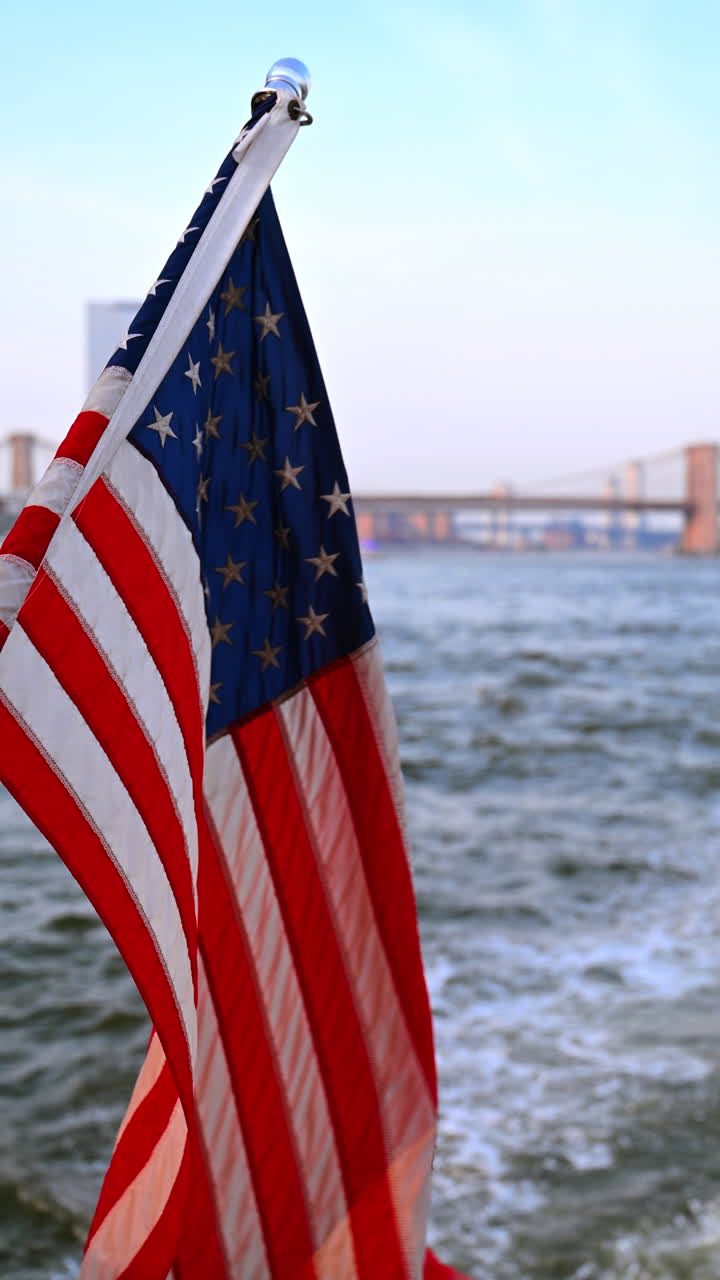 Primo piano della bandiera americana su una barca a New York. Primo piano della bandiera degli Stati Uniti che sventola su una barca con fiume e ponte sullo sfondo