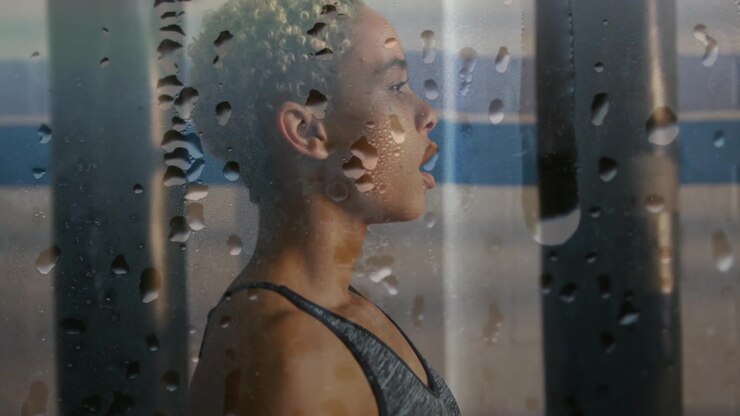 Sweaty Athlete Resting After Workout Behind Glass With Water Droplets