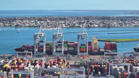 aerial view of cranes loading container ships at melbourne’s victoria international container terminal in port phillip bay
