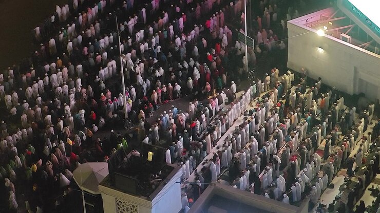 Large Crowd of People Performing Islamic Prayer at Night