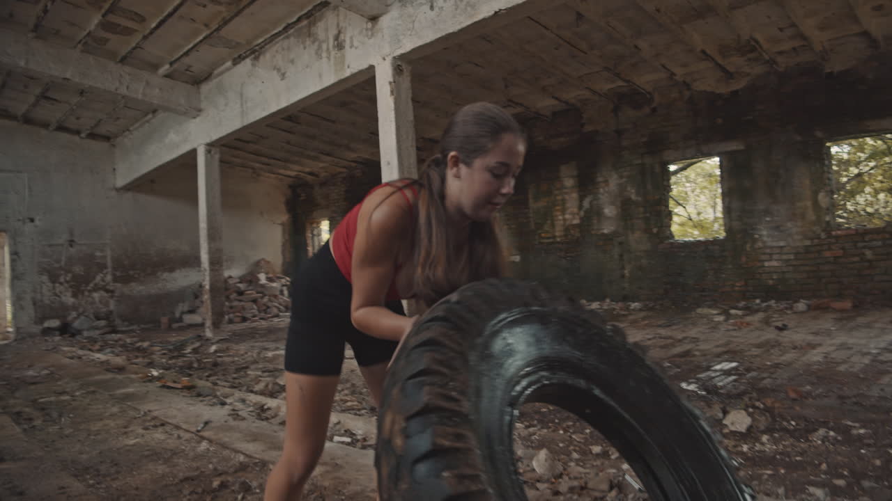 mujer joven trabajando con un neumático grande