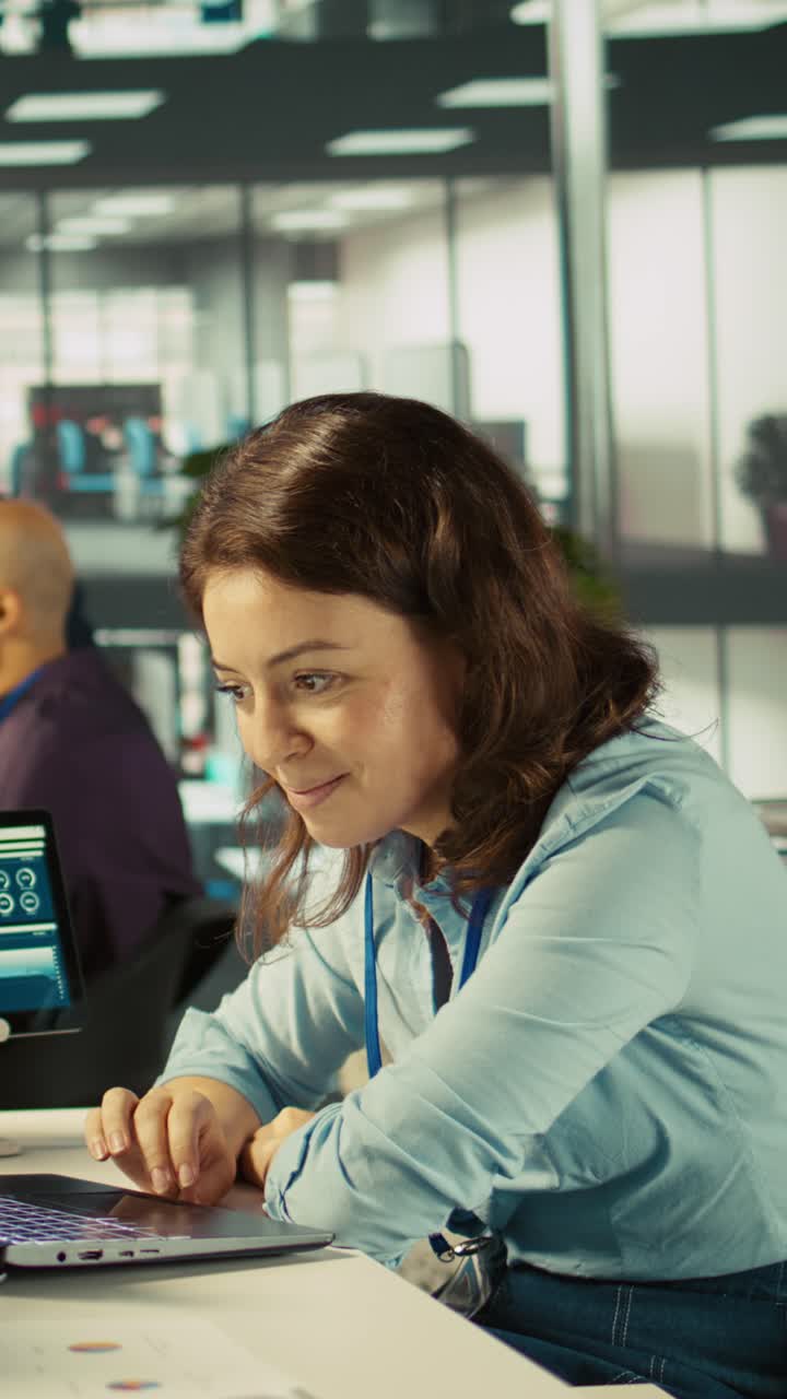 Vertical video Accountant in busy modern startup agency imputing financial figures on PC