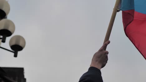 Slow-Motion-of-Czech-National-Flag-in-Hand-of-Man-Waving-in-Prague-City-Exterior-Close-Up