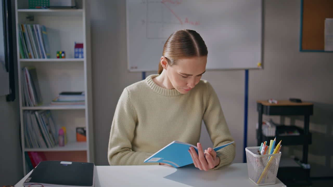 Rolig lærer som retter feil i leksene i klassen nærbilde. Lærer på jobb
