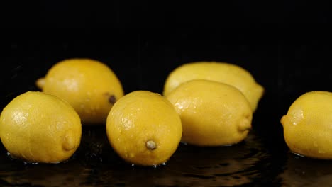 limones frescos cayendo gotas de agua con un salto.