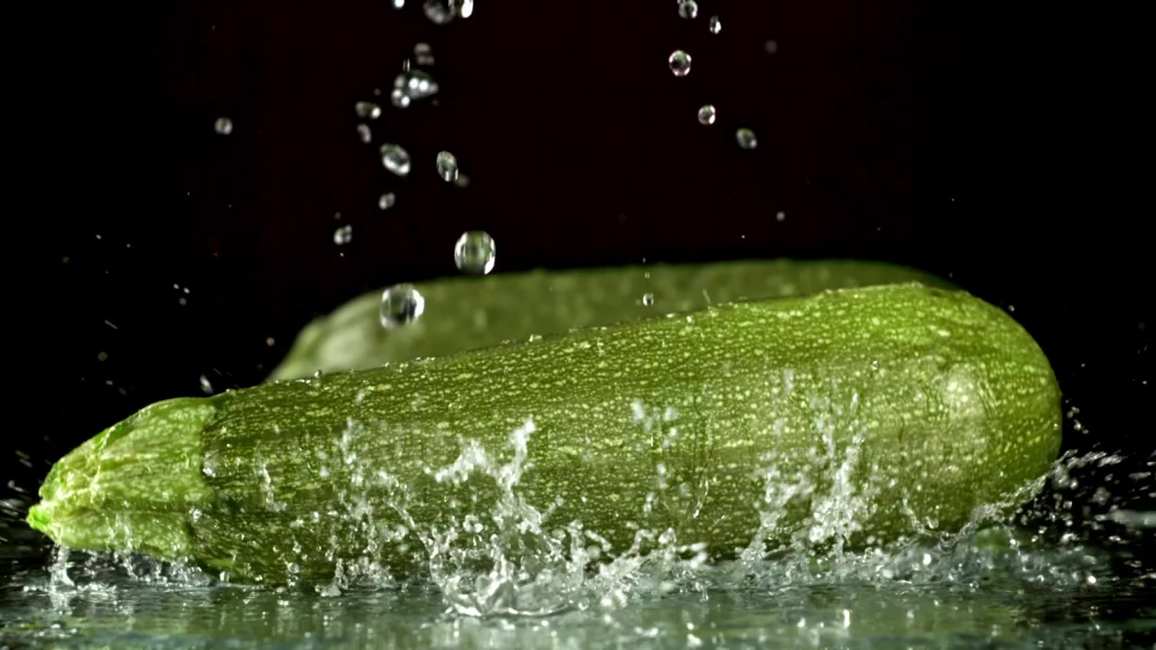 Zucchine Verdi Fresche che Cadono nell'Acqua con Schizzi