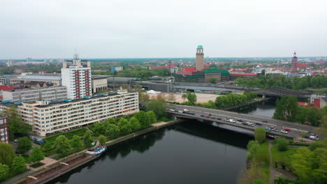 Imágenes-Aéreas-De-Una-Concurrida-Carretera-De-Varios-Carriles-En-Un-Puente-Sobre-El-Agua-Y-Edificios-De-Apartamentos-En-El-Paseo-Marítimo-Del-Río-Havel.-Torre-Del-Ayuntamiento-En-Segundo-Plano.-Berlín,-Alemania