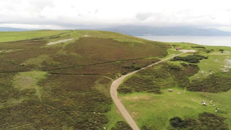 Aerial-view-flying-above-Great-Orme-Llandudno-mountain-valley-following-rural-landscape-summit