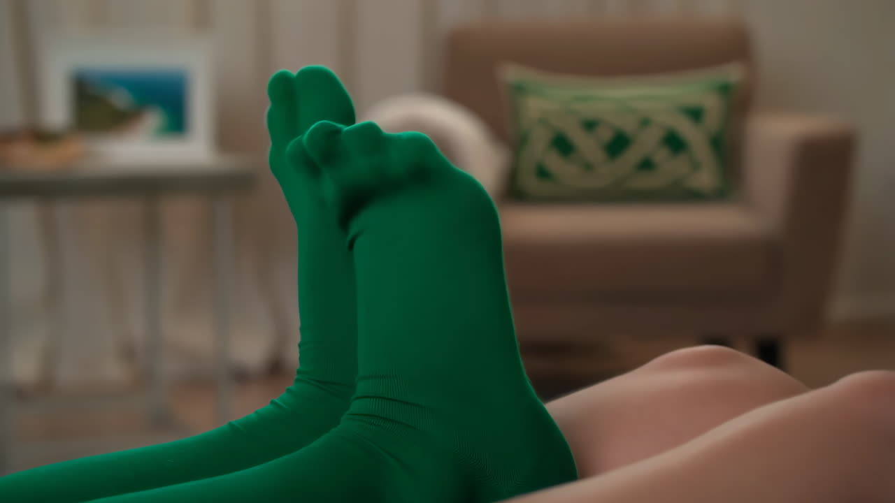 Legs in Green Tights Relaxing Indoors