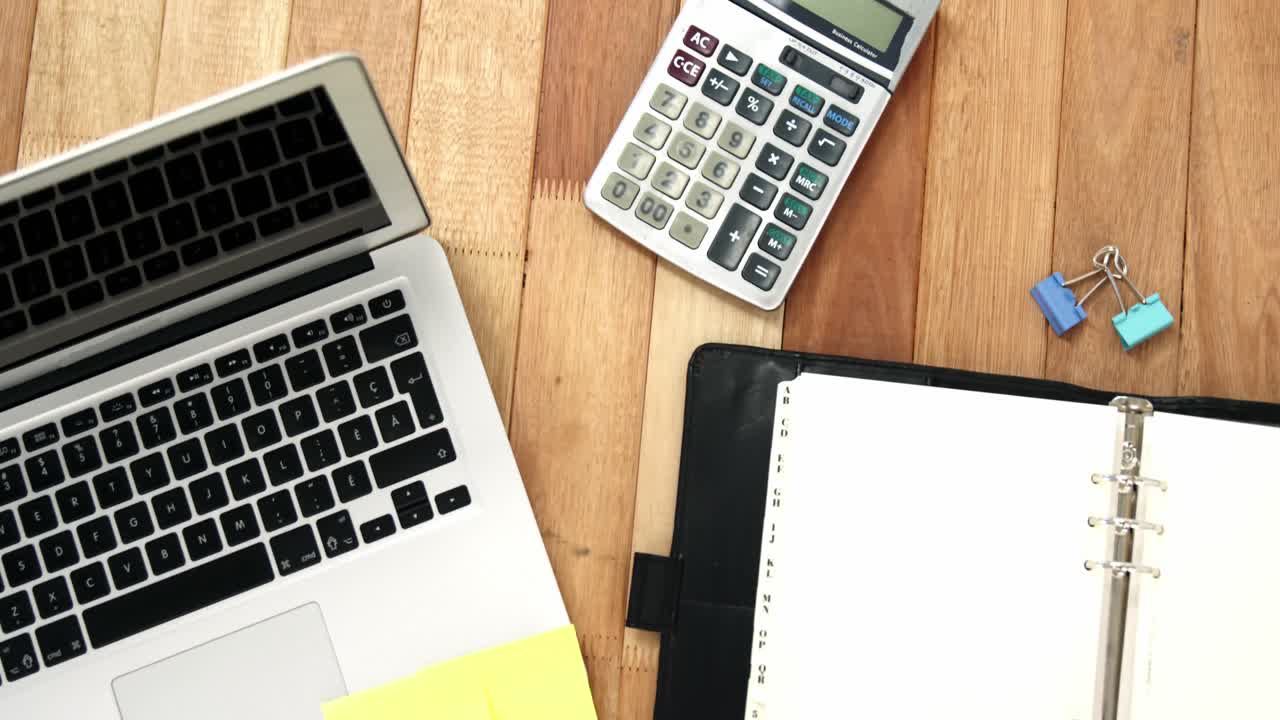 portátil con carpeta, nota adhesiva y calculadora