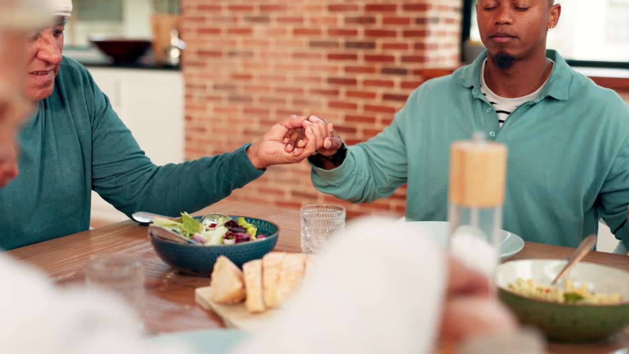 Family Holding Hands and Praying Together Before a Meal