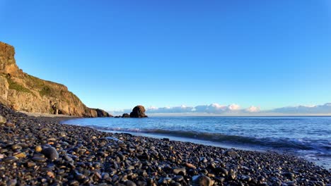 Zeitlupe,-Nasser-Kiesstrand,-Ruhige-See-Und-Blauer-Himmel,-Kupferküste,-Waterford,-Irland