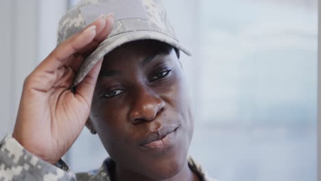 Portrait-of-african-american-female-soldier-taking-off-cap-and-smiling-in-hospital,-in-slow-motion