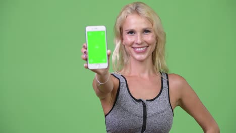 young happy beautiful woman showing phone ready for gym