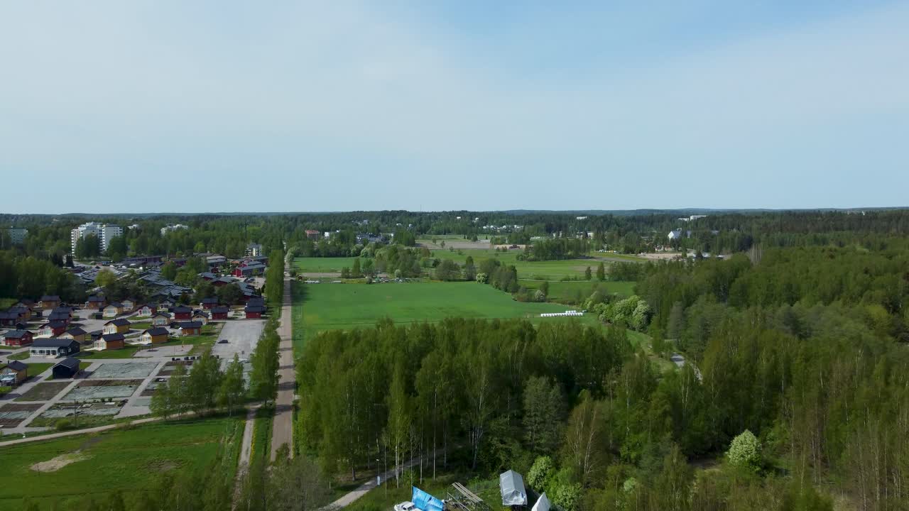 A lush green forest surrounds the city, and a drone hovers above, capturing the breathtaking scenery that combines nature's beauty with urban life