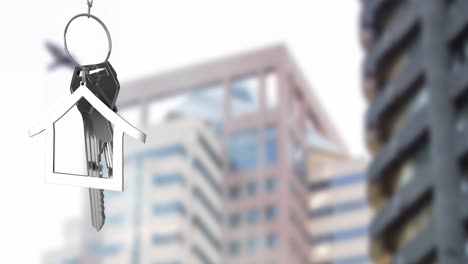 Animation-of-hanging-silver-house-keys-against-blurred-view-of-tall-buildings