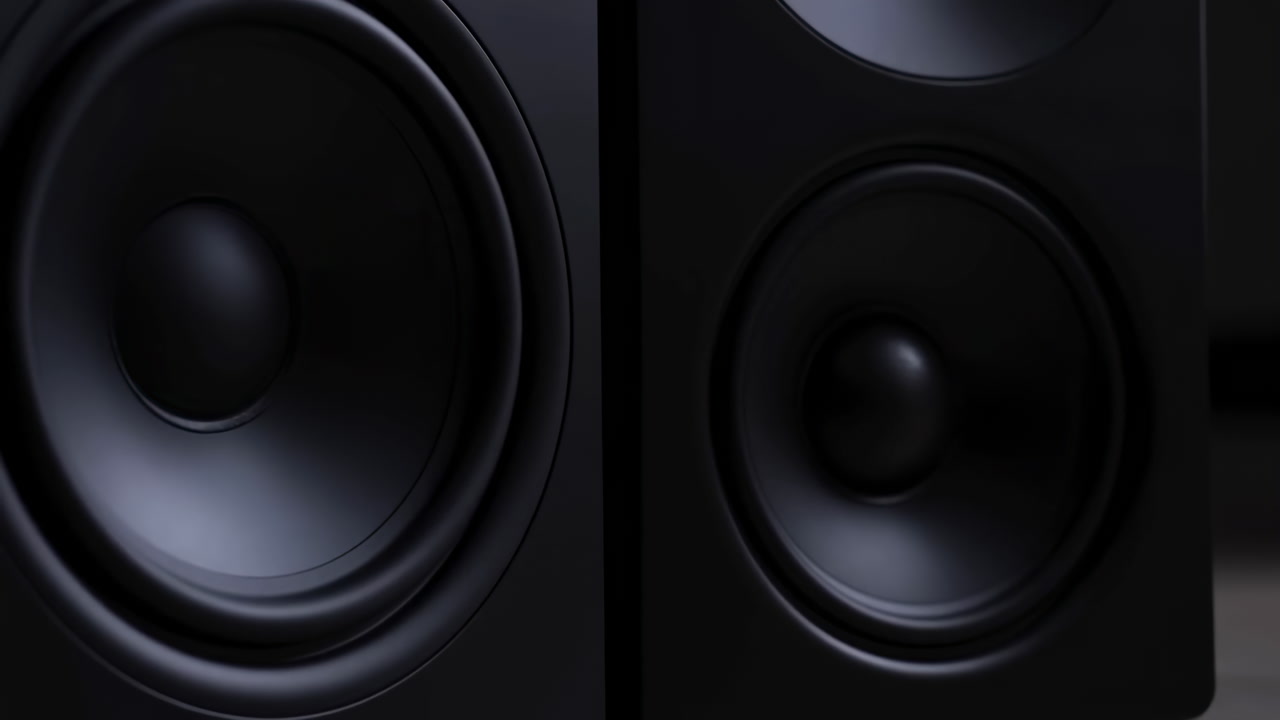 Closeup Black Studio Speakers Front View Showing Glossy Woofer Cones And Textured Cabinet In Low Light,