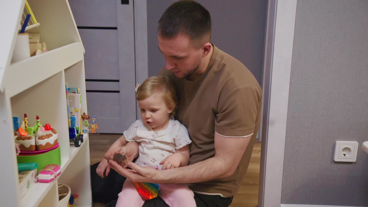 Padre e bambina piccola che giocano con i giocattoli a casa