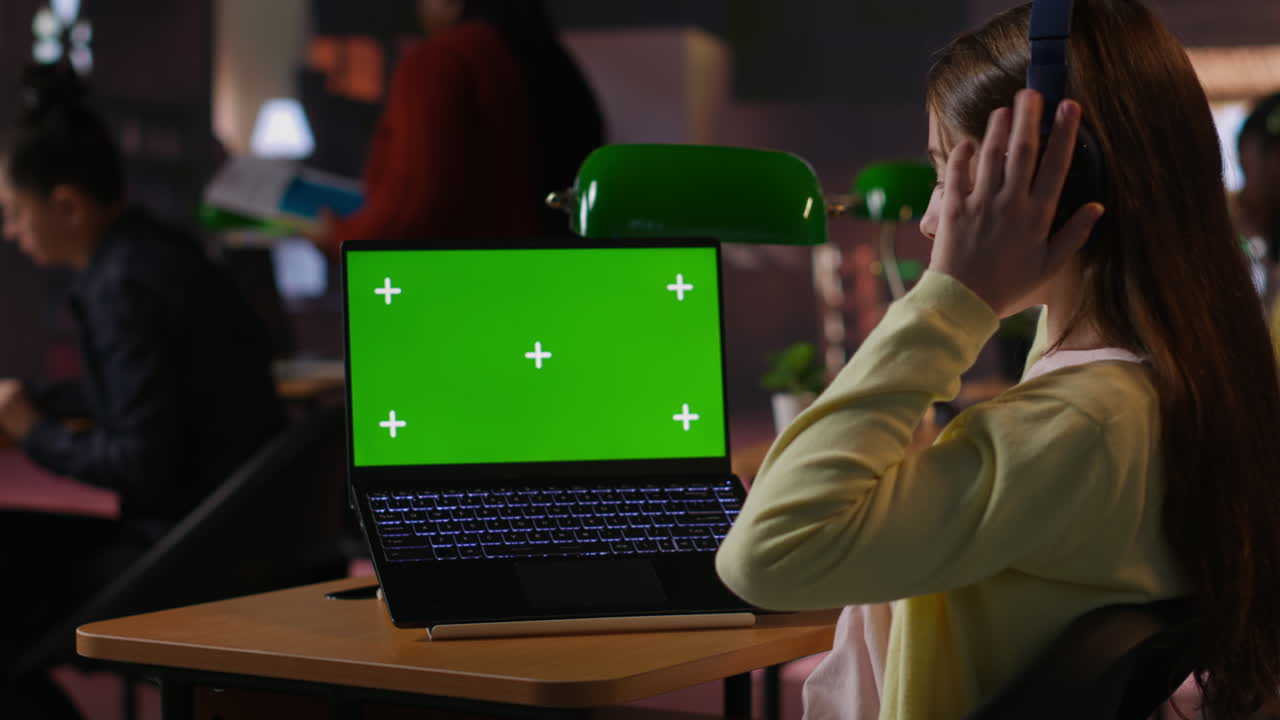 chica estudiando en una computadora portátil con pantalla verde
