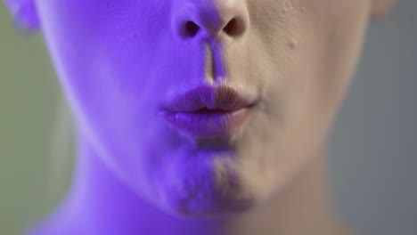 close up of woman's mouth eating crispy nacho chip, studio shot with colorful lighting