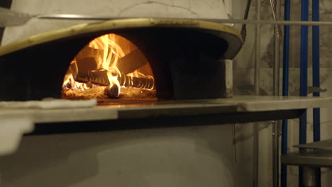 a wood burning fire in a neapolitan style pizza oven in a nice restaurant