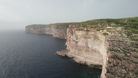 Vista-Aérea-De-Una-Costa-Rocosa-En-Xlendi-Bay,-Isla-De-Gozo,-Malta