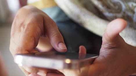 close-up of hands holding and using a smartphone