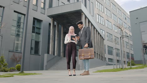 business colleagues discussing project outside modern office building