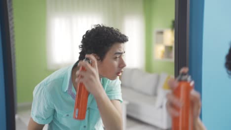 Hübscher-Junge,-Der-Vor-Dem-Spiegel-Haarspray-Auf-Sein-Lockiges-Haar-Sprüht.