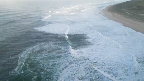 waves crashing near a beautiful beach in nazare, portugal, with a peaceful ocean view