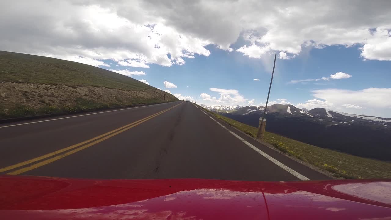 Coche rojo conduciendo a la cima del Parque Nacional de las Montañas Rocosas