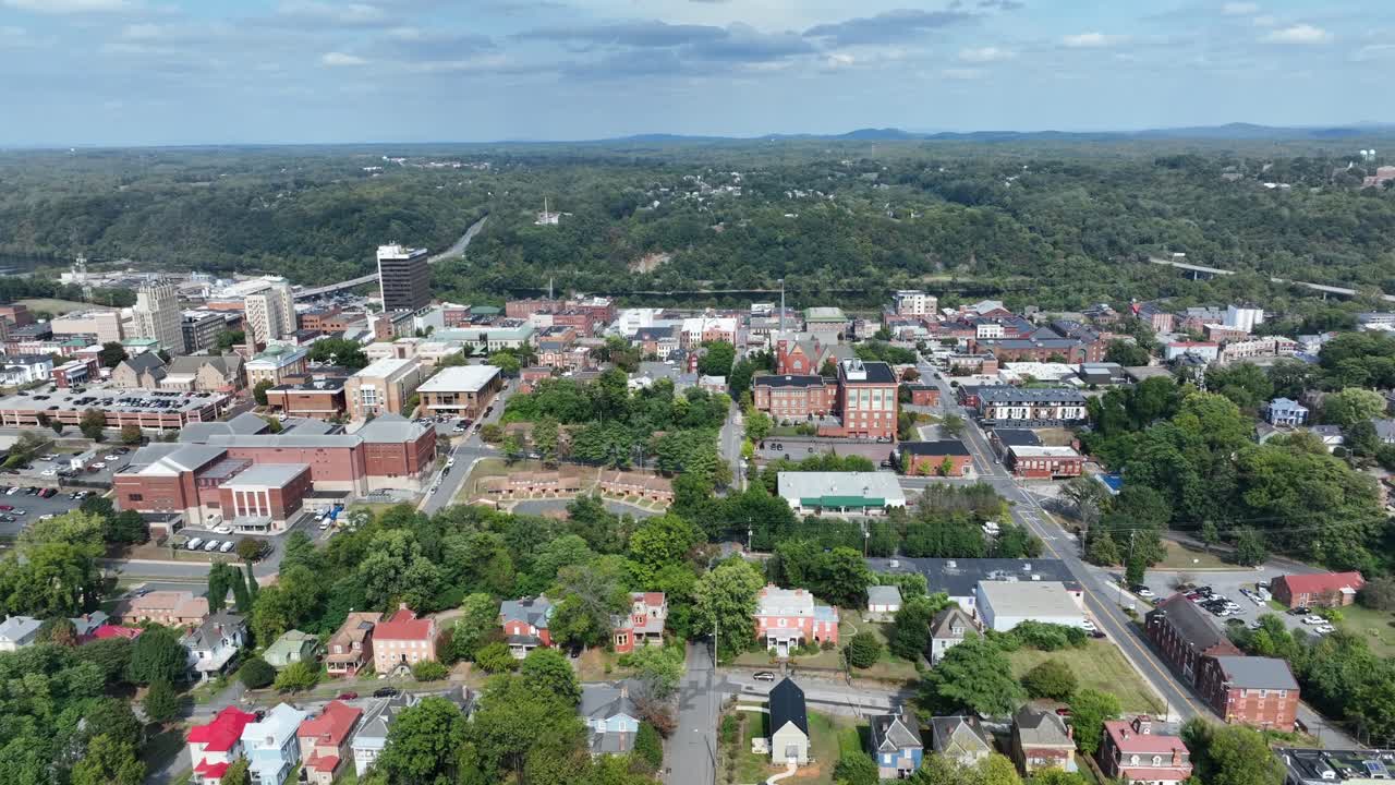 Downtown of American City with red brick buildings and houses. Aerial rising wide shot. Forest landscape in Virginia, USA