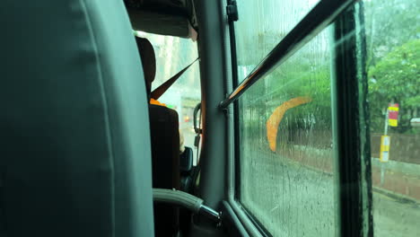 static shot on a bus going through busy roads in hong kong on a rainy day