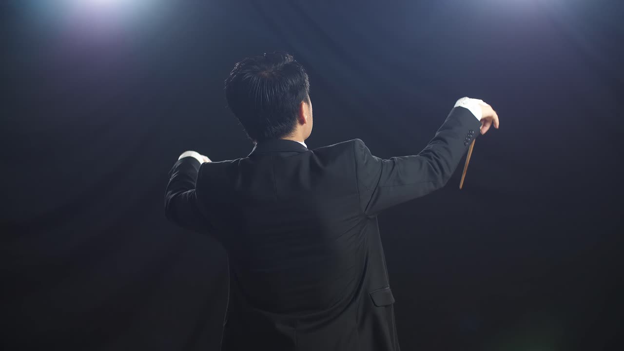 흑인 스튜디오에서 지이를 들고 몸짓을 하는 아시아인 지휘자