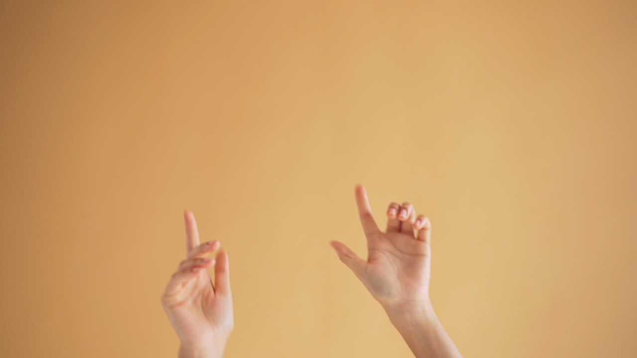 Hands in Motion against Light Orange Background