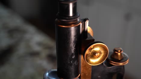 borrosa y luego presione para revelar un microscopio antiguo con perillas de latón brillante - macro