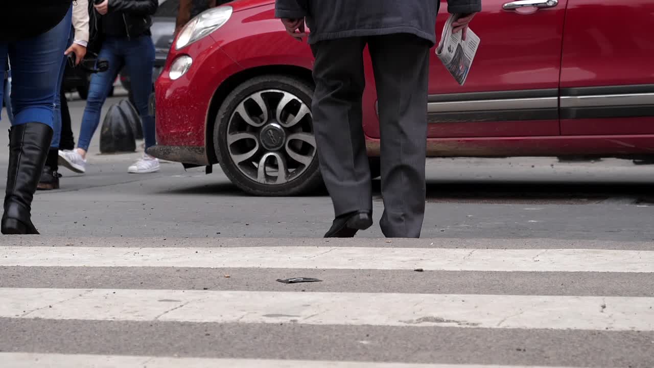 Low Angle View of People's Legs Walking Across a Busy City Crosswalk