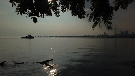toronto skyline at sunset with tugboat
