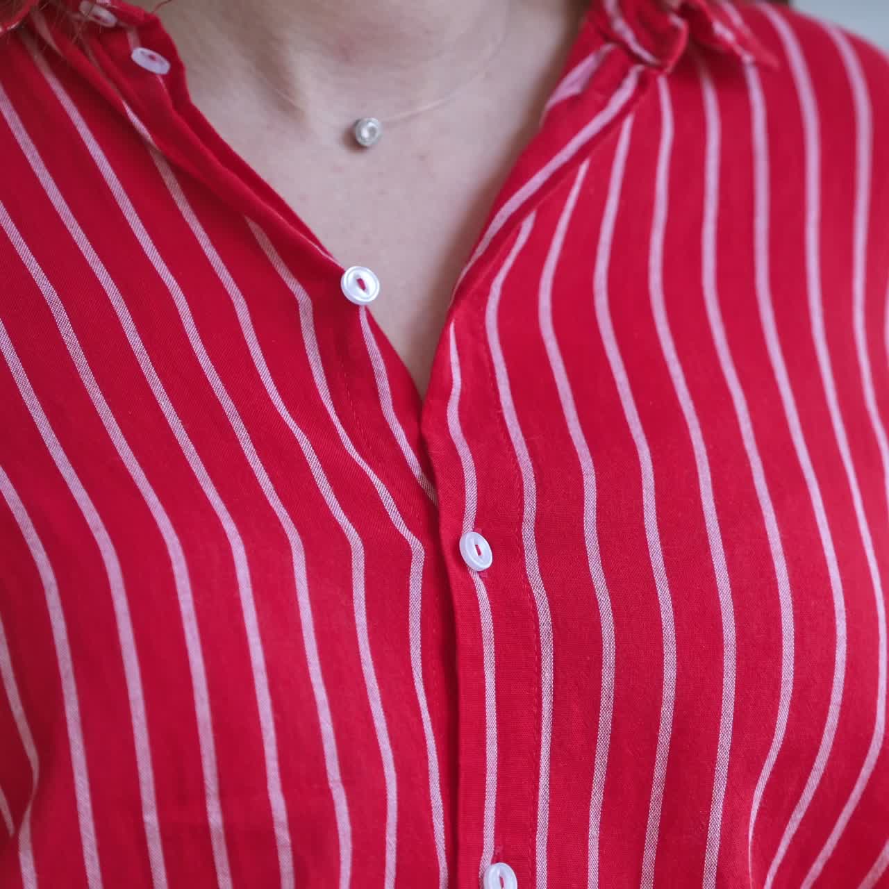 Woman hands close up buttons on shirt