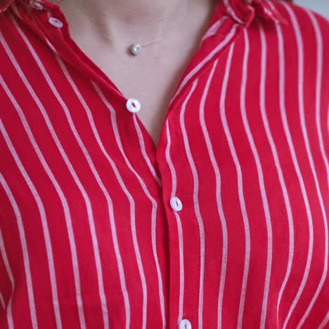 woman hands close up buttons on shirt