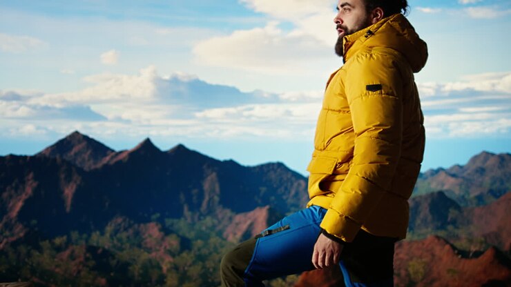 Adventure seeker gazes at the valley and mountain peaks ahead